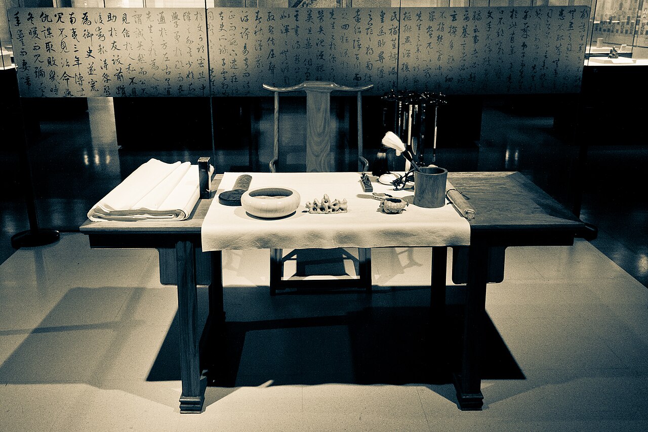 Traditional Chinese calligraphy implements including brush ink stick Xuan paper and Duan inkstone