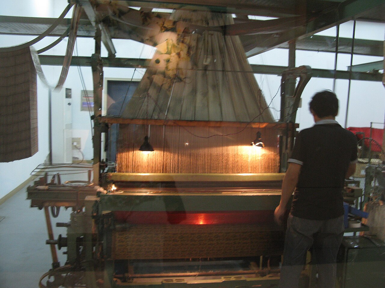 A traditional Chinese silk drawloom with wooden frame and intricate thread arrangement for brocade weaving