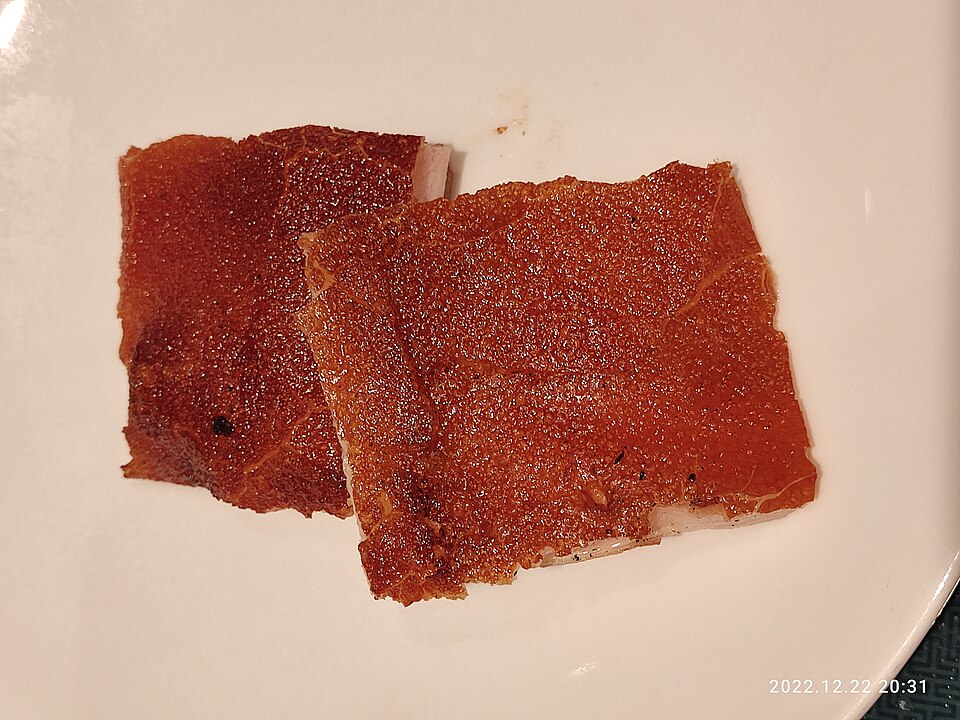 Two pieces of crispy roasted pork belly served on a white plate