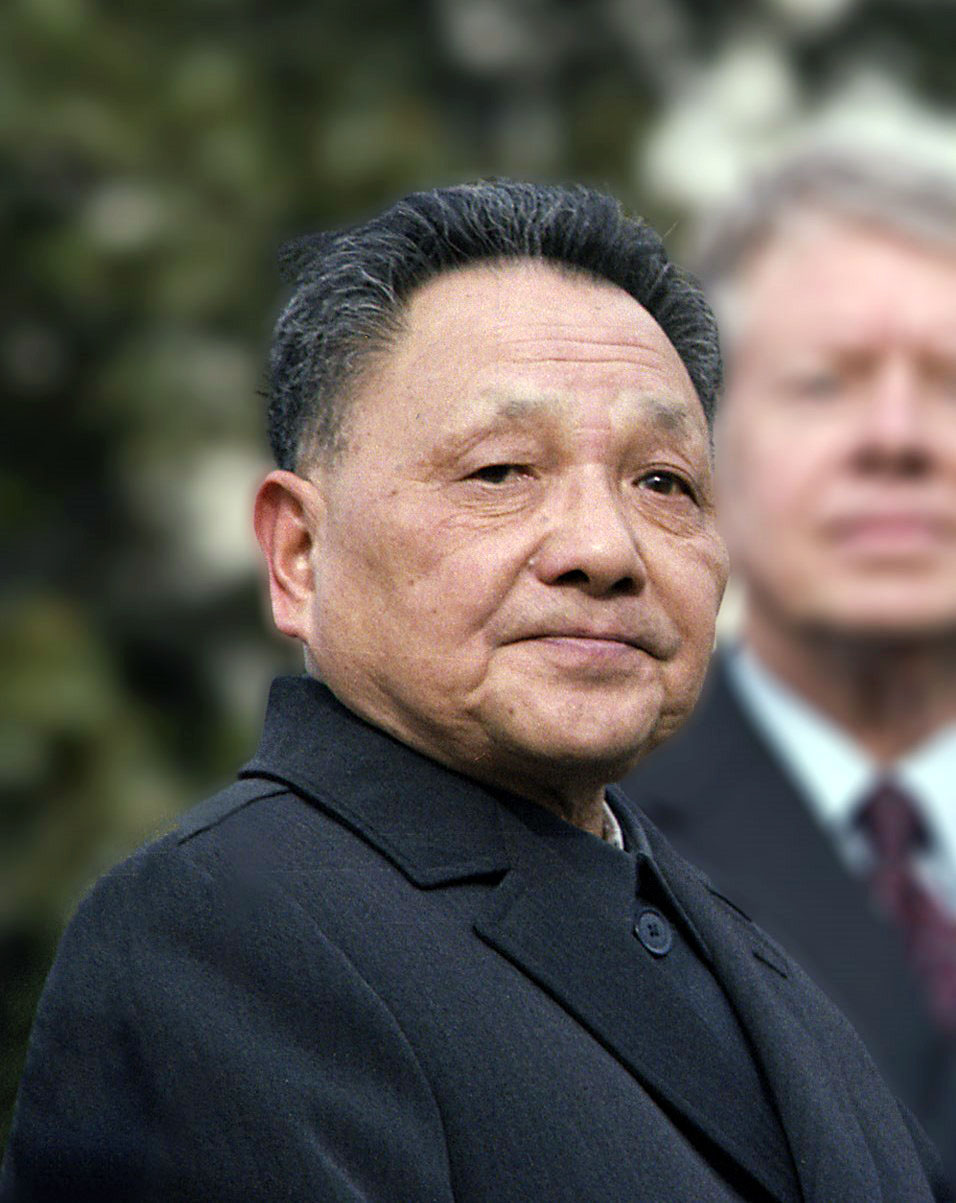 Close-up portrait of Deng Xiaoping in a dark Mao suit with Jimmy Carter visible in the background