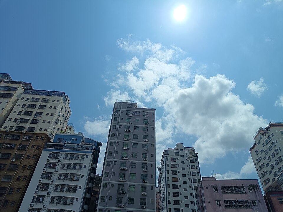 Mid-rise residential apartment buildings in Shenzhen against a blue sky with clouds