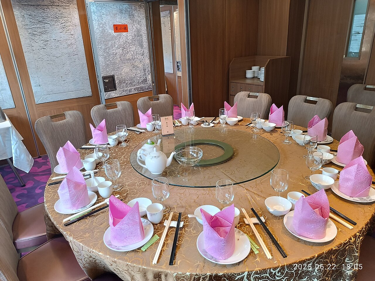 Formal Chinese banquet table with lazy Susan, folded napkins, and precise place settings