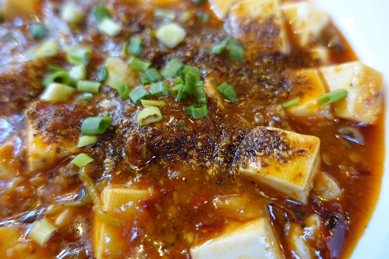 A bowl of mapo tofu with chili oil and Sichuan peppercorns
