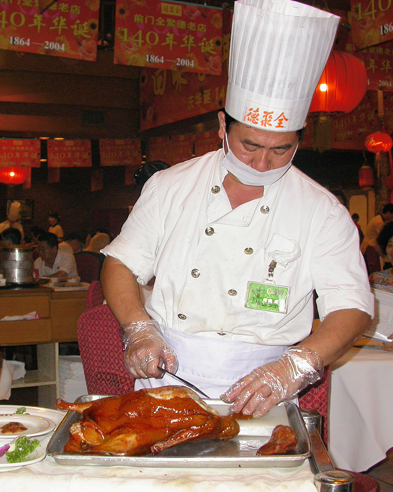 Chef carving Peking duck at Quanjude restaurant in Beijing