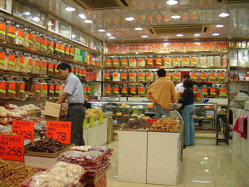 Interior of a traditional Chinese medicine shop in Hong Kong with shelves of dried herbs and customers being served