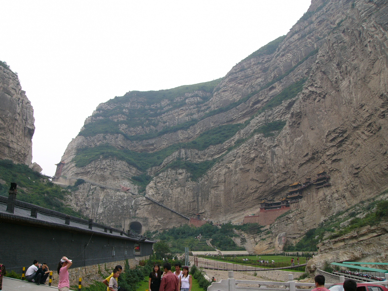 Traditional Chinese Buddhist monastery built into a mountain cliff face surrounded by mist