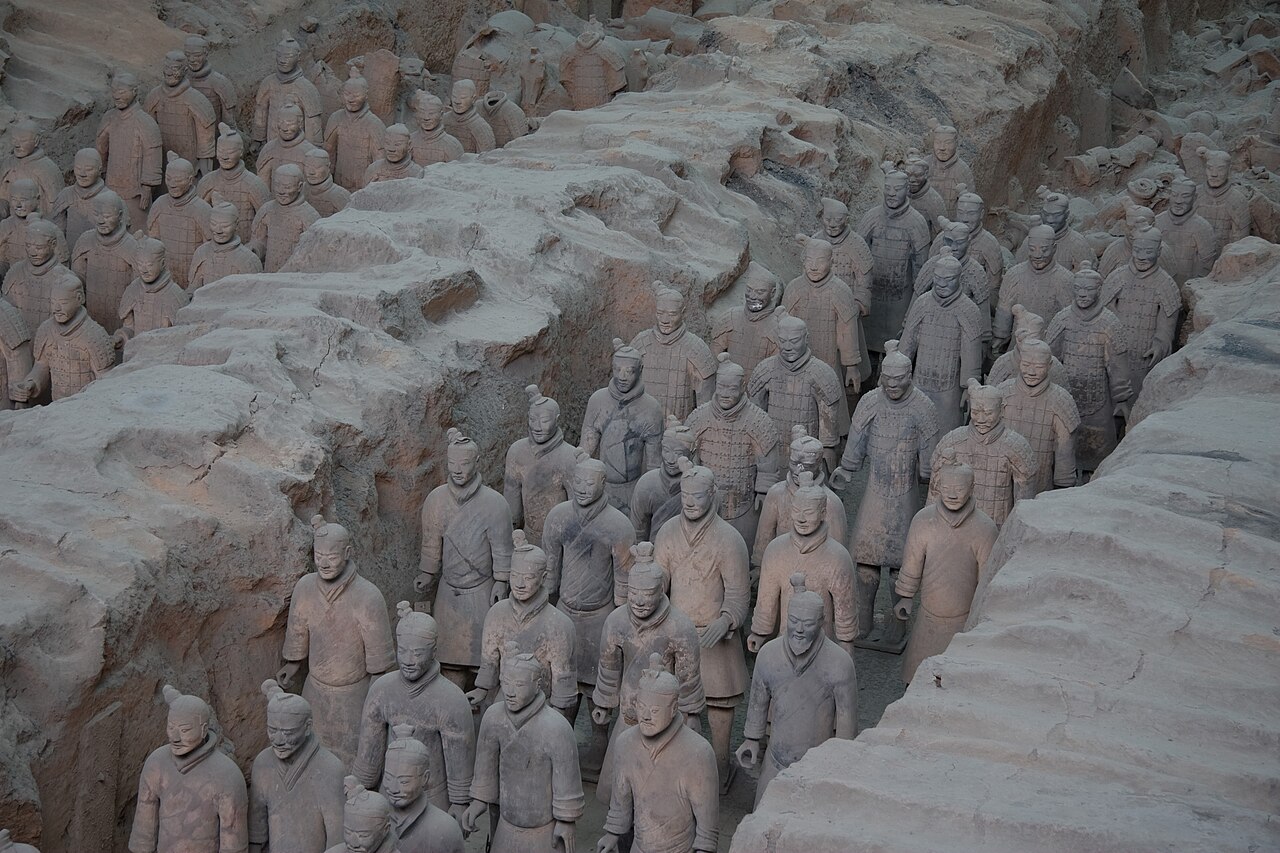 Rows of terracotta warriors standing in excavation trenches near Xi'an
