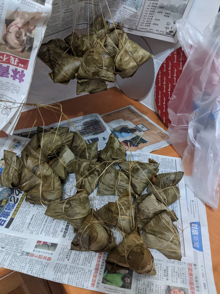 Bundles of freshly wrapped zongzi rice dumplings tied with string on a table